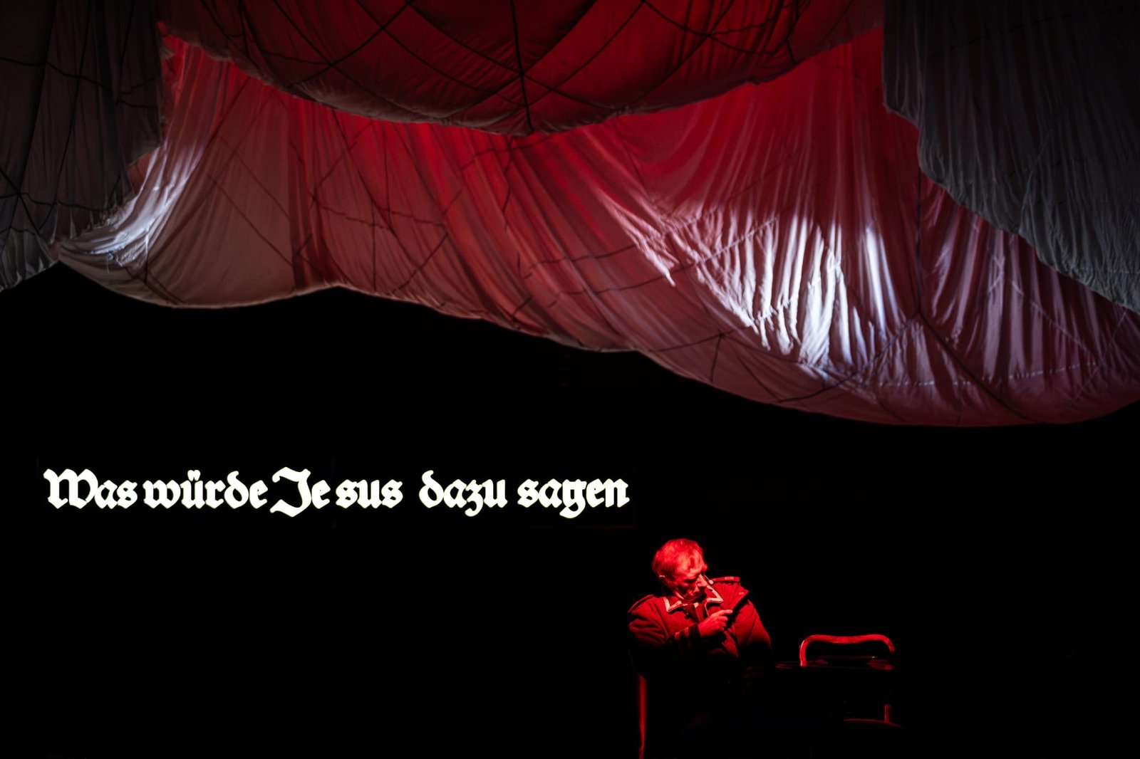 Napis z projekcji nad sceną w czerwieni